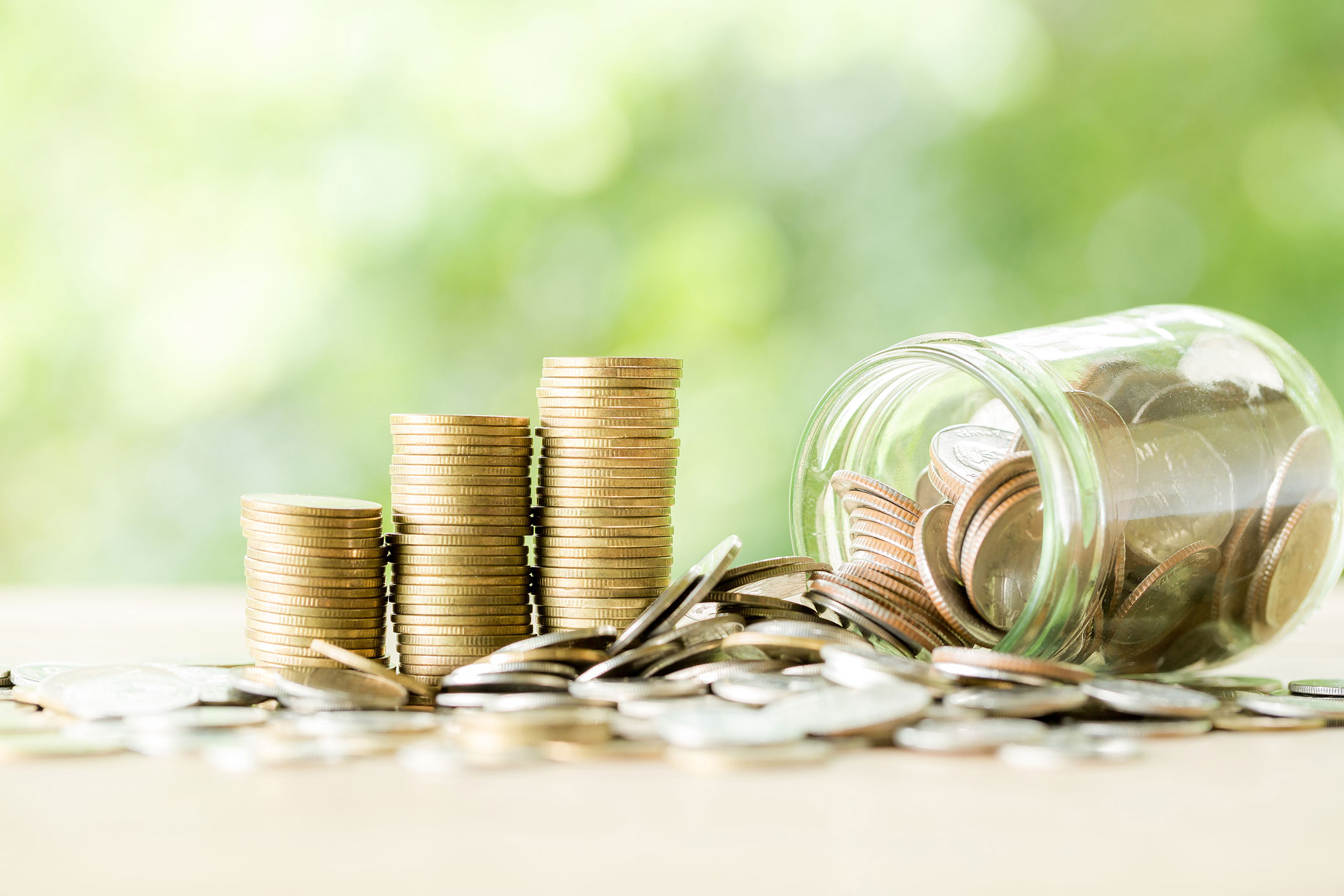 Coin on wooden table in front of green bokeh background.